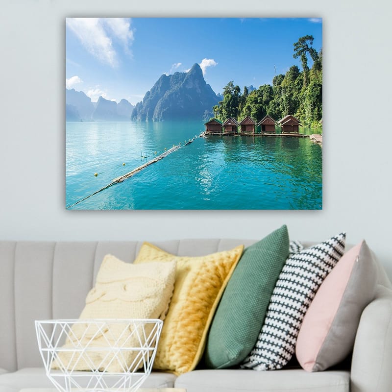 Lerretsbilde 70x100 cm - Vakker innsjø med hytter ved vannet, omgitt av majestetiske fjell og frodig skog - Turkis / Grønn / Brun - Innredning - Bilder & kunst - Lerretsbilder