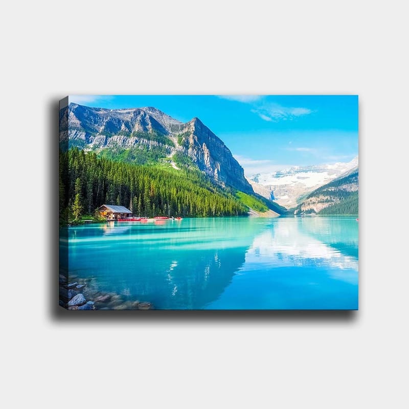 Lerretsbilde 70x100 cm - Vakker innsjø omgitt av majestetiske fjell og tett grøntområde, Turkis / Grønn / Blå