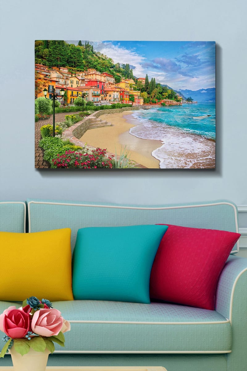 Lerretsbilde 70x100 cm - Vakker kystlinje med fargerike hus som klatrer opp en frodig ås ved en strand - Blå / Grønn / Gul - Innredning - Bilder & kunst - Lerretsbilder