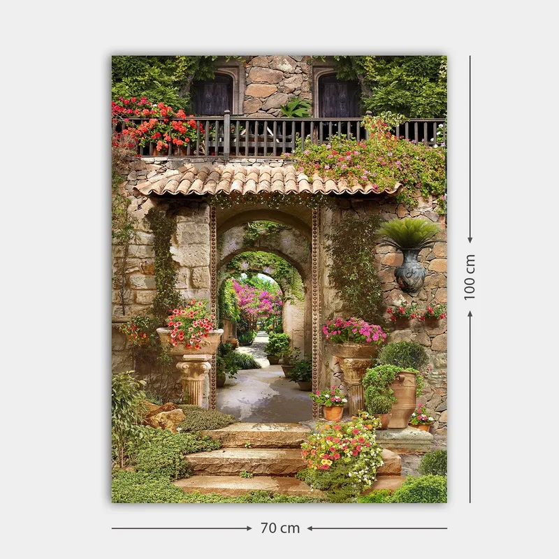 Lerretsbilde 70x100 cm - Vakker og frodig hage med blomsteroppsatser og en steinbue som fører inn til en løvrik gangvei - Grønn / Rosa / Beige - Innredning - Bilder & kunst - Lerretsbilder