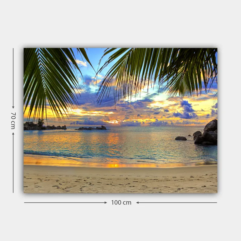 Lerretsbilde 70x100 cm - Vakker solnedgang over en strand med palmer som rammer inn motivet - Blå / Oransje / Grønn - Innredning - Bilder & kunst - Lerretsbilder