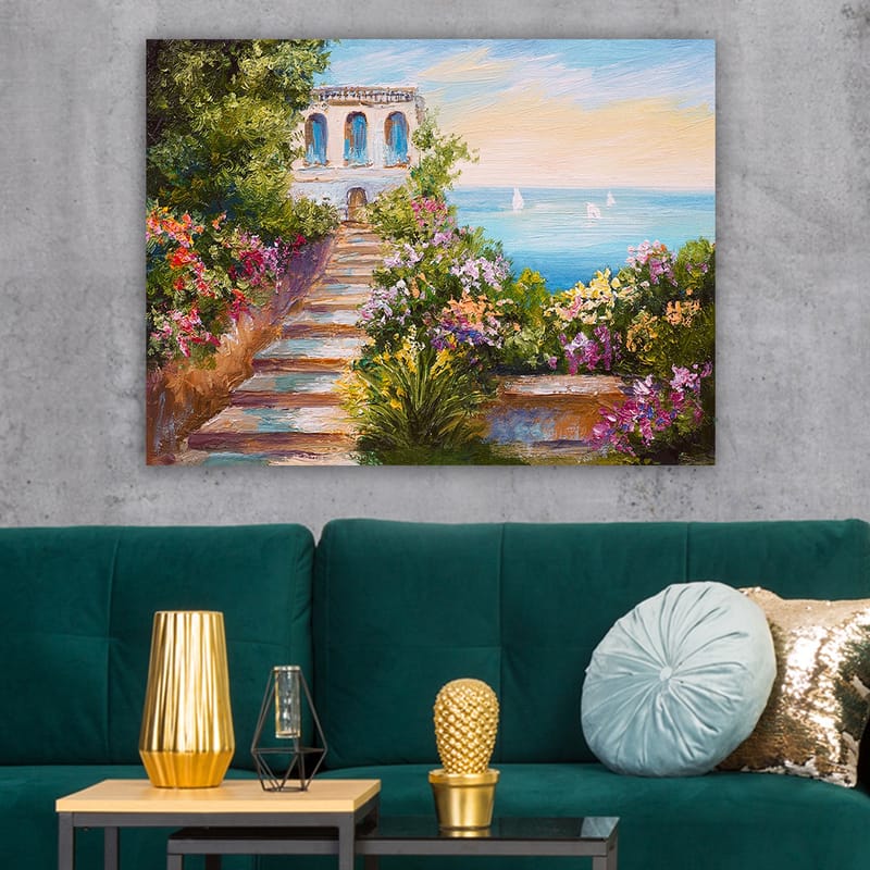 Lerretsbilde 70x100 cm - Vakker trapp omgitt av fargerike blomster som fører ned til havet og en bygning med blå vinduer - Grønn / Rosa / Blå - Innredning - Bilder & kunst - Lerretsbilder