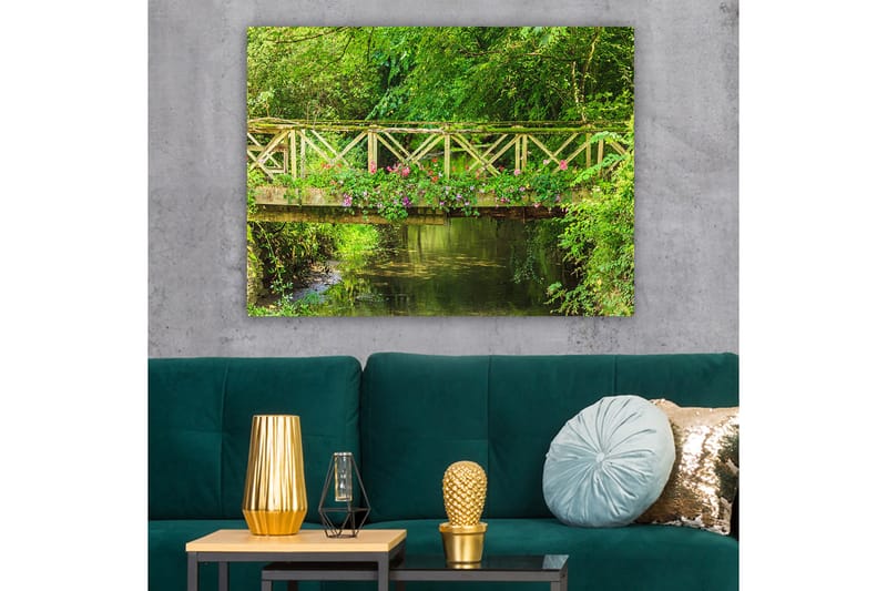 Lerretsbilde 70x100 cm - Vakker trebro omgitt av grøntområder og blomster ved en rolig vannflate - Grønn / Rosa / Brun - Innredning - Bilder & kunst - Lerretsbilder