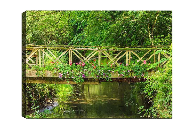 Lerretsbilde 70x100 cm - Vakker trebro omgitt av grøntområder og blomster ved en rolig vannflate, Grønn / Rosa / Brun