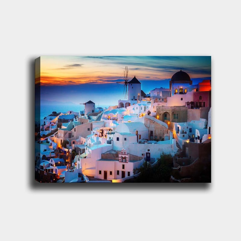Lerretsbilde 70x100 cm - Vakker utsikt over de hvite husene i en gresk landsby ved solnedgang, Hvit / Blå / Oransje