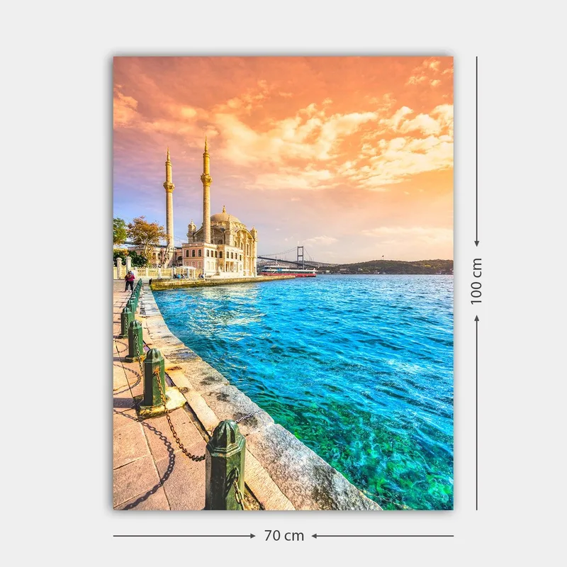Lerretsbilde 70x100 cm - Vakker utsikt over en moské ved vannet med en bro i bakgrunnen under en fargerik himmel - Blå / Oransje / Beige - Innredning - Bilder & kunst - Lerretsbilder