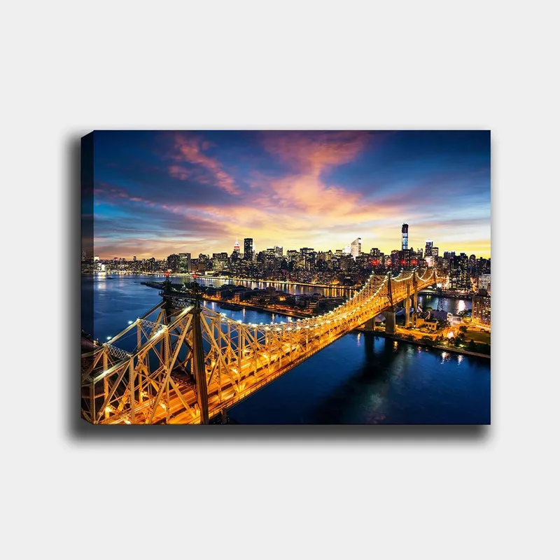 Lerretsbilde 70x100 cm - Vakker utsikt over Queensboro Bridge med en bysilhuett i bakgrunnen under en fargerik solnedgang - Blå / Oransje / Gul - Innredning - Bilder & kunst - Lerretsbilder