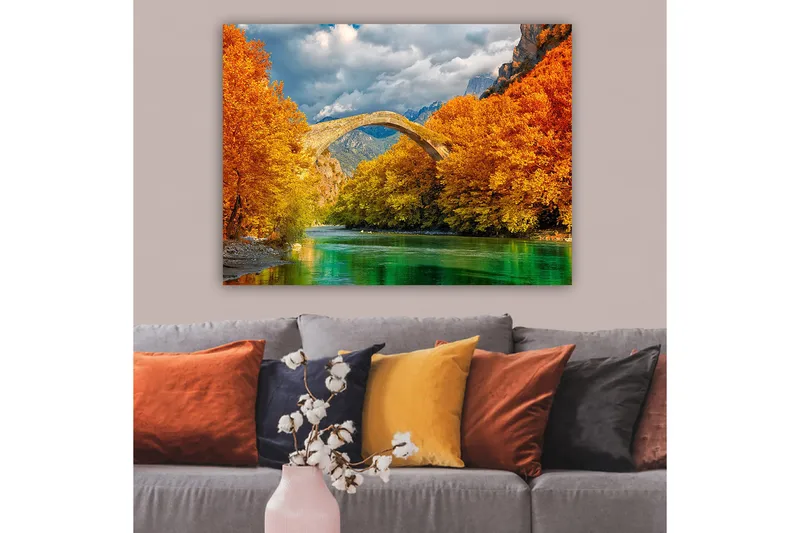 Lerretsbilde 70x100 cm - Vakkert høstlandskap med en gammel steinbro som strekker seg over en glitrende elv omgitt av fargerike trær - Oransje / Grønn / Blå - Innredning - Bilder & kunst - Lerretsbilder