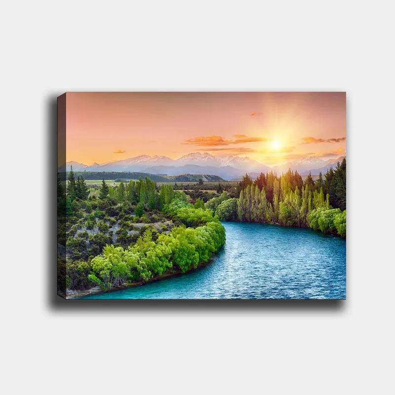 Lerretsbilde 70x100 cm - Vakkert landskapsmaleri med en elv som slynger seg gjennom frodige trær og fjell i bakgrunnen under en soloppgang - Grønn / Blå / Oransje - Innredning - Bilder & kunst - Lerretsbilder