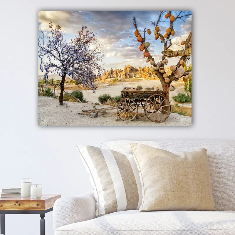 Lerretsbilde 70x100 cm - Vakkert landskapsmaleri med en gammel vogn og blomstrende trær i naturskjønne omgivelser, Lilla / Oransje / Beige