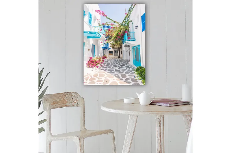 Lerretsbilde 70x100 cm - Pittoresk bakgate med hvite hus og fargerike blomster i middelhavsmiljø - Blå / Rosa / Hvit - Innredning - Bilder & kunst - Lerretsbilder