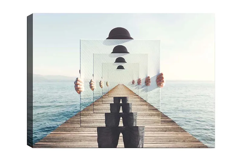 Lerretsbilde 70x100 cm - Person som holder opp flere gjennomsiktige paneler som skaper en illusjon av dybde og perspektiv på en brygge ved vannet, Blå / Svart / Hvit
