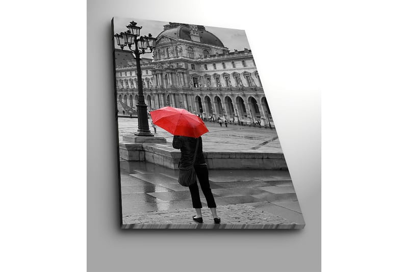 Lerretsbilde 70x100 cm - Person som står med en rød paraply i et regnfullt bymiljø foran en historisk bygning - Rød / Svart - Innredning - Bilder & kunst - Lerretsbilder