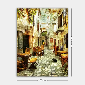 Lerretsbilde 70x100 cm - Pittoresk smug med trebord og stoler, omgitt av gamle steinhus - Brun / Grå / Grønn - Innredning - Bilder & kunst - Lerretsbilder