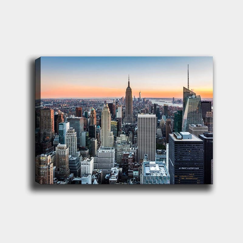Lerretsbilde 70x100 cm - Panoramautsikt over New York City med ikoniske skyskrapere i solnedgangens lys, Blå / Grå / Oransje