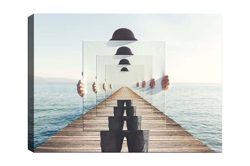 Lerretsbilde 70x100 cm - Person som holder opp flere gjennomsiktige paneler som skaper en illusjon av dybde og perspektiv på en brygge ved vannet, Blå / Svart / Hvit