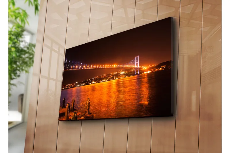 Lerretsbilde 70x45 cm - Opplyst bro over en glitrende vannflate ved mørkets frembrudd - Mørk blå / Oransje / Svart - Innredning - Bilder & kunst - Lerretsbilder