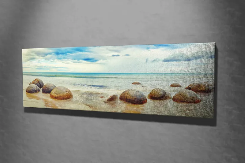 Lerretsbilde 80x30 cm - Runde steiner på en strand med hav og himmel i bakgrunnen - Blå / Beige / Grå - Innredning - Bilder & kunst - Lerretsbilder
