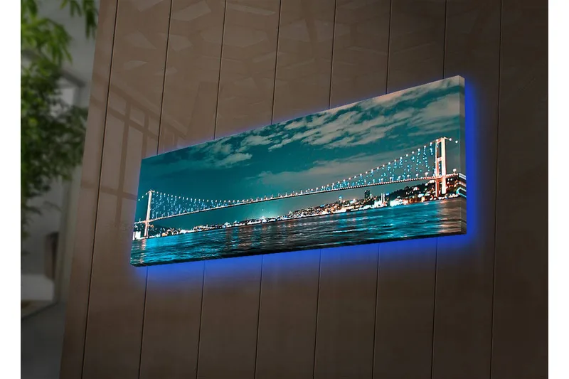 Lerretsbilde med LED-belysning 30x90 cm - Bro over et rolig vann med bylys i bakgrunnen, Mørk blå / Turkis / Lys grønn