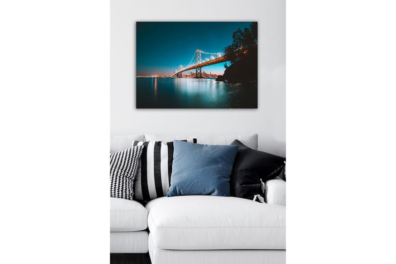 Lerretsbilde - Opplyst bro over en stille vannflate med byens skyline i bakgrunnen - Blå / Oransje / Svart - Innredning - Bilder & kunst - Lerretsbilder